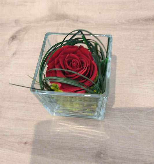 Composition de rose rouge dans vase cube